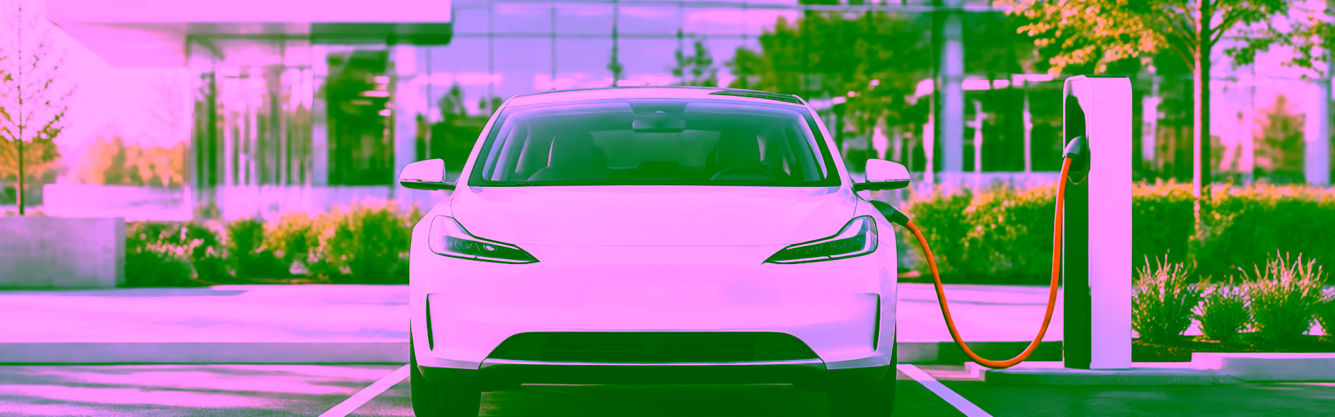 Elektro-Dienstwagen lädt an einer Ladesäule auf dem Firmenparkplatz – Symbol für Elektromobilität in der Lohnabrechnung